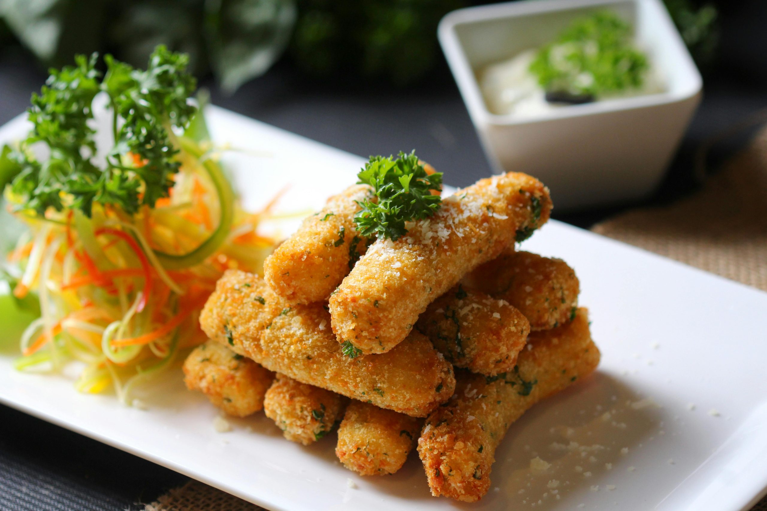 Delicious crispy mozzarella sticks served with fresh vegetable salad and creamy dipping sauce.